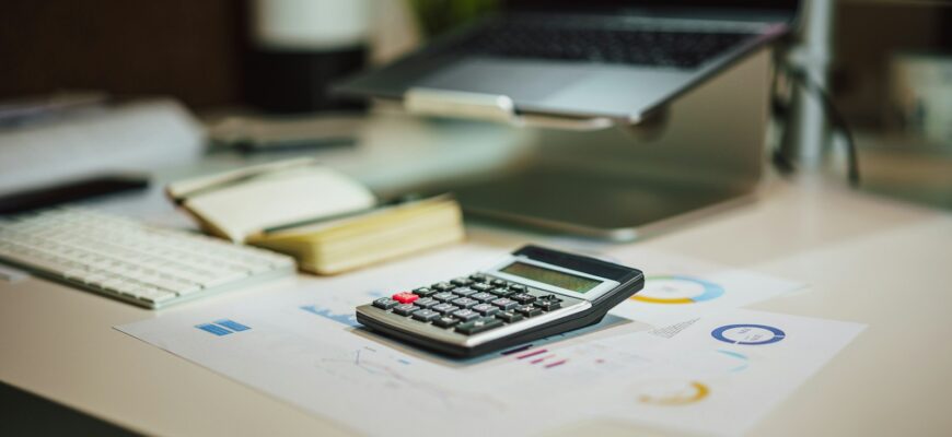 a calculator sitting on top of a table next to a laptop