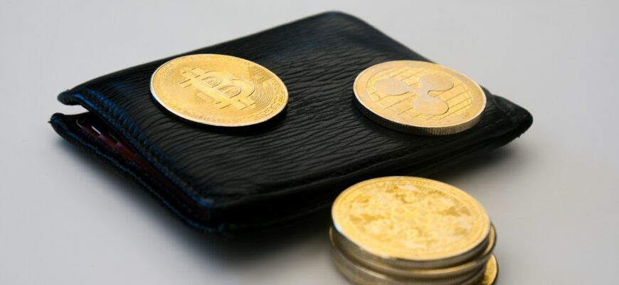 a wallet with three gold coins sitting on top of it