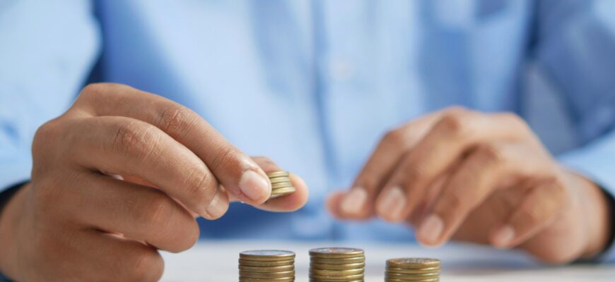 a person stacking coins on top of a table