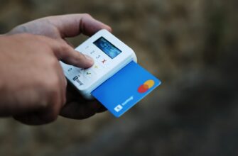 a hand holding a credit card and a cell phone