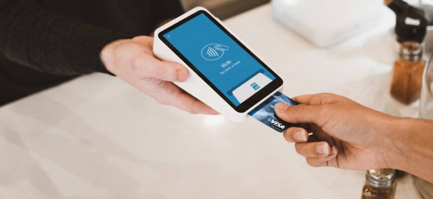 person putting magstripe card near black card terminal