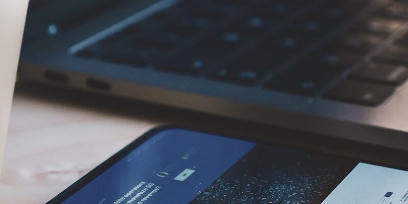 black android smartphone beside black laptop computer