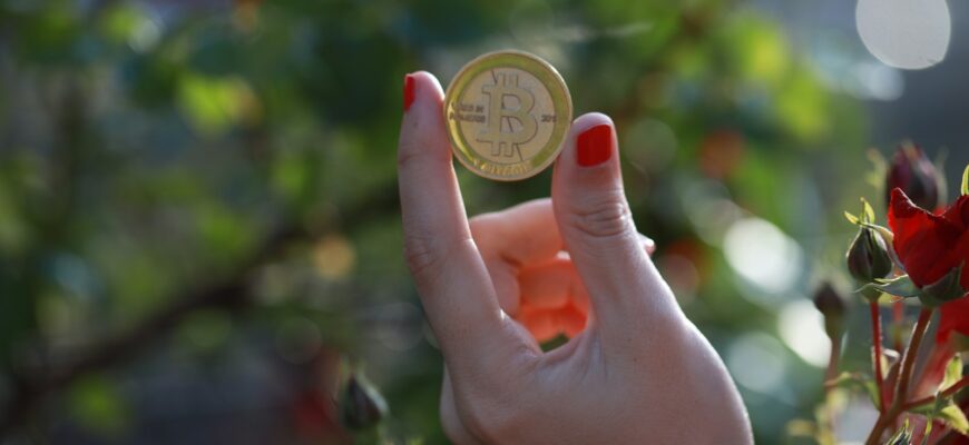 a person holding a bit coin in their hand